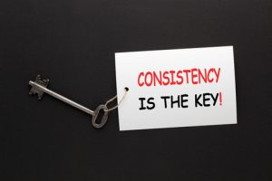 An image of a key tied to a paper that says "Consistency is the key!"